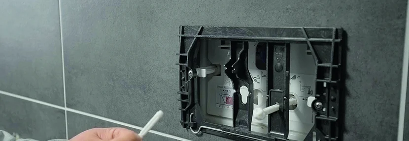 Person hält Stift an Spülkasten